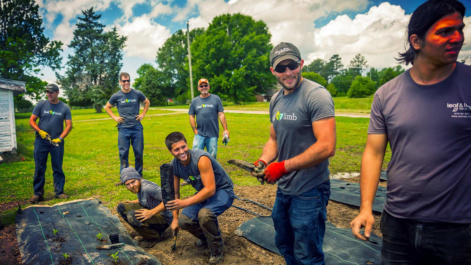 A group of Leaf & Limb team members smiling together outdoors.