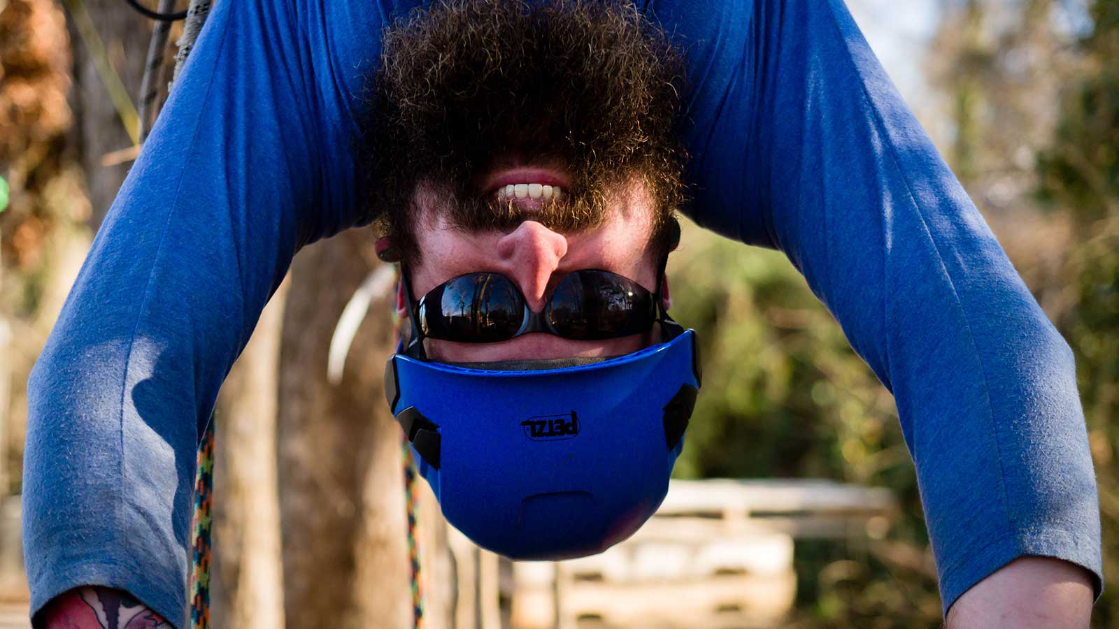 Tree climber using safety equipment and harness in a tree.