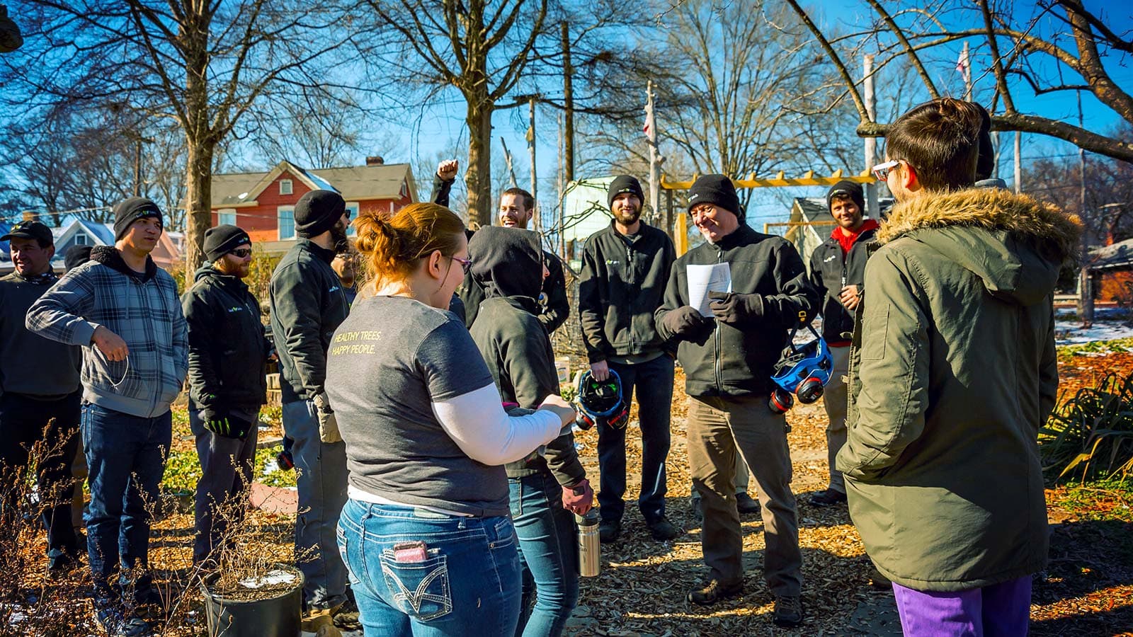 Volunteers collecting native tree seeds in a community garden.